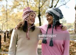 Two women wearing sweaters